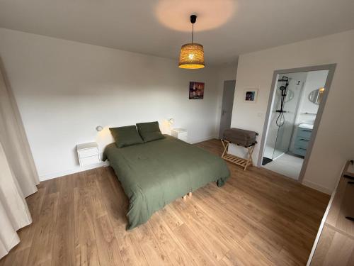 a bedroom with a bed with a green blanket at La Parenthèse du golfe chambre d hôte in Arradon