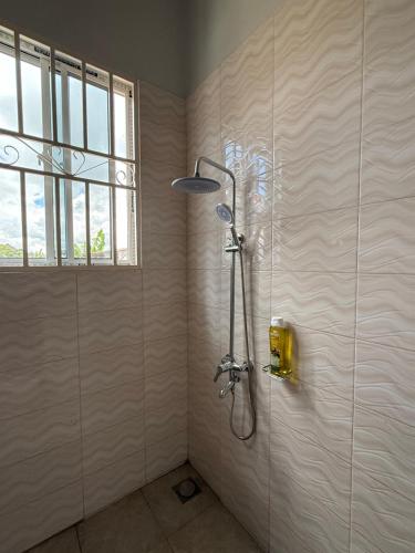 a shower stall in a bathroom with a window at Bluetooth home stay in Arusha