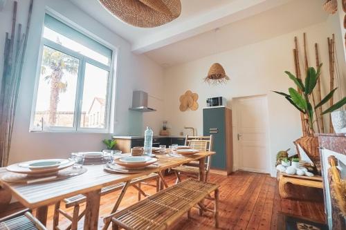 une salle à manger avec une table et des chaises en bois dans l'établissement L'Escale Balinaise & Spa Appartement lumineux et spacieux, à Agen