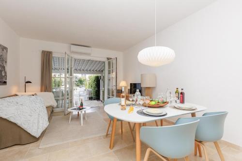une salle à manger et un salon avec une table et des chaises dans l'établissement Une Maison Un Ponton Plein D Options YourHostHelper, à Grimaud