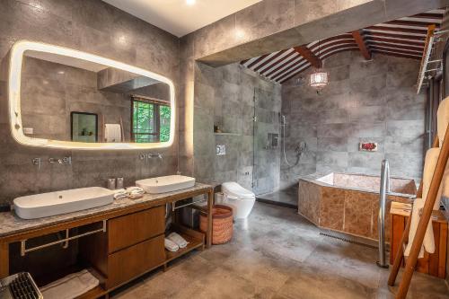 a bathroom with two sinks and a tub and a mirror at 南京又见江南民宿 in Nanjing