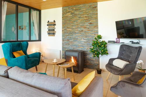 un salon avec un canapé et une cheminée dans l'établissement Vue Mt-St-Michel, Élégance, calme et baby-foot Bonzini, à Dragey-Ronthon