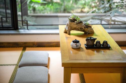 a wooden table with plants on it next to a window at 南京又见江南民宿 in Nanjing