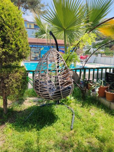 a bird cage sitting on the grass in a yard at Pınar Vintage House in Pamukkale