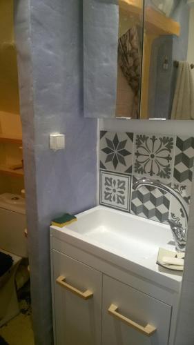 une salle de bain avec un lavabo blanc et un miroir dans l'établissement Maisonnette typique, coeur du village médiéval de Sauve, à Sauve