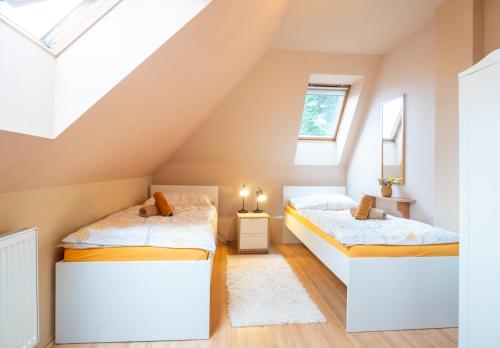 two beds in a room with a attic at Vila Lumír in Poděbrady