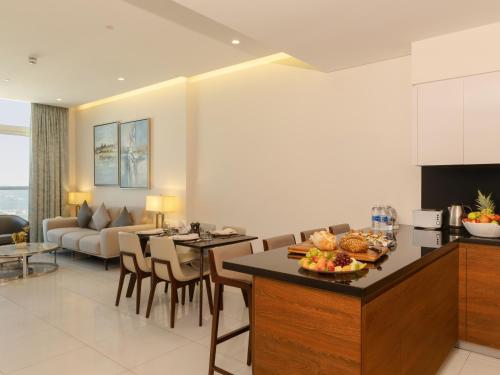 a kitchen and living room with a table with food on it at Swiss-Belsuites Admiral Juffair in Manama