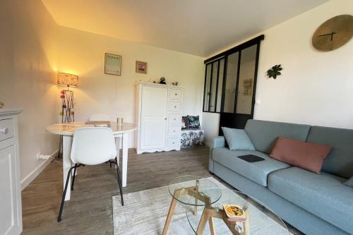 a living room with a blue couch and a table at Appartement, Cabourg Plage, Centre ville - Aquilon in Cabourg