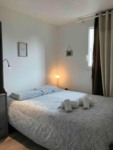 une chambre avec un lit avec deux oreillers dessus dans l'établissement Appartement, Cabourg Plage, Centre ville - Aquilon, à Cabourg