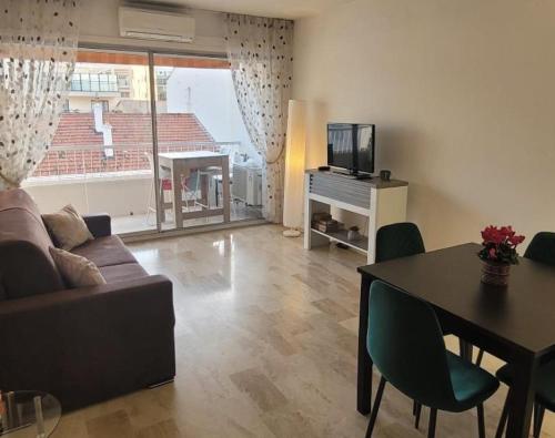 un salon avec un canapé, une table et une télévision dans l'établissement Center Cannes Montfleury, à Cannes