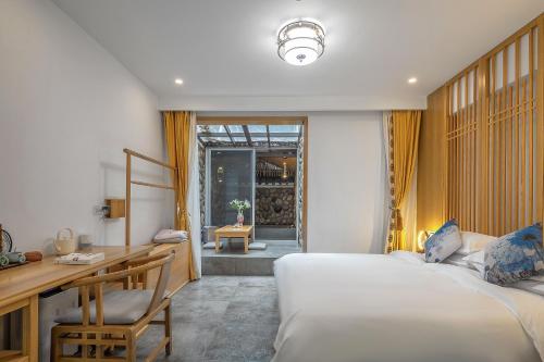 a bedroom with a desk and a bed and a desk and chair at 南京又见江南民宿 in Nanjing