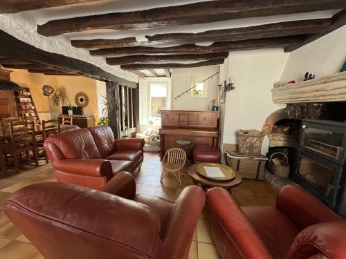 a living room with leather furniture and a fireplace at Chambres d'hôtes "Là Je Ris" in Lagery