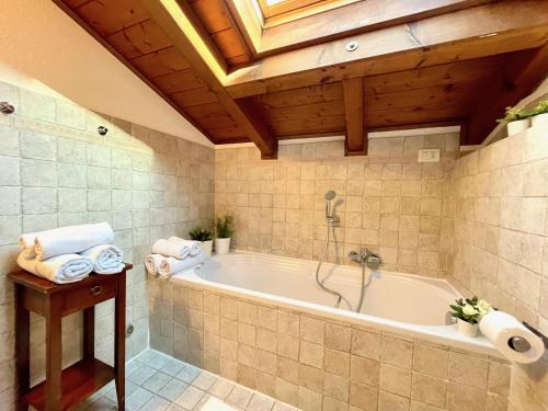 a bathroom with a bath tub with a wooden ceiling at Casa Lory in Bellagio