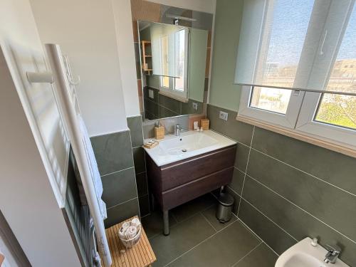 a bathroom with a sink and a mirror and a toilet at Raffaello's House - Aeroporto Falconara - Ancona in Ancona Falconara Airport