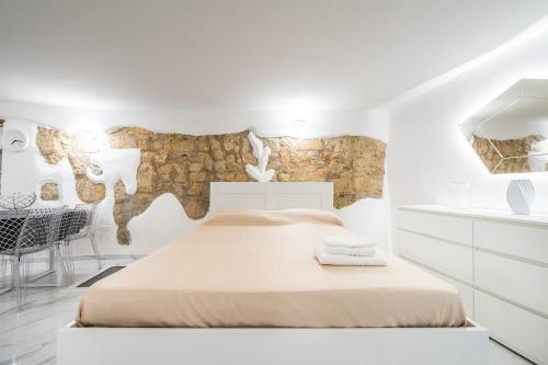 a white bedroom with a large bed and a table at Family JC in Cagliari