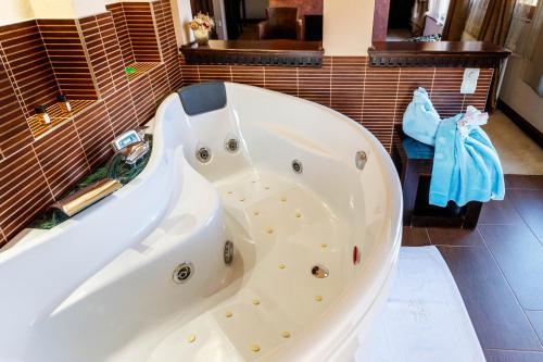a white bath tub sitting in a bathroom at Hotel Vila Lago in Palić