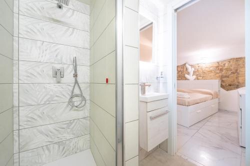 a white bathroom with a shower and a sink at Family JC in Cagliari