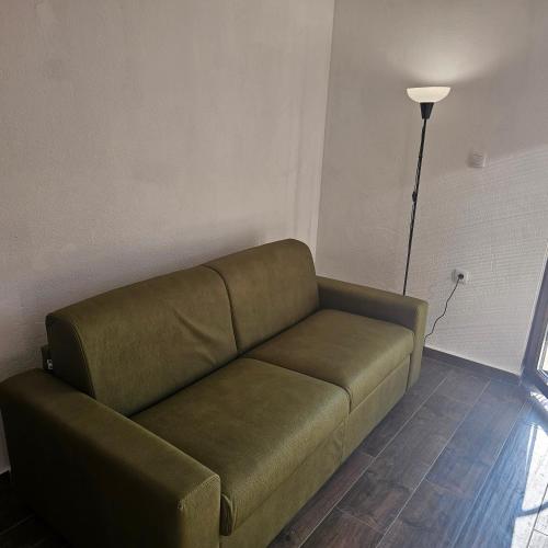 a green couch in a room with a lamp at InesAna in Kotor