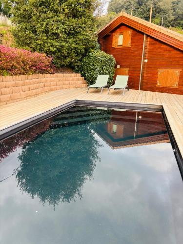 une piscine avec deux chaises et une maison dans l'établissement U Mo Sognu, à Murzo