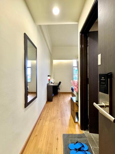 a hallway with a mirror and a desk in a room at Central City Hotel at Chinatown in Kuala Lumpur