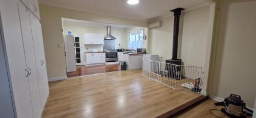 a kitchen with a wood floor and a stove in it at Private room for couple in Esperance in Esperance