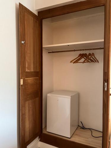 a small refrigerator in a closet with a wooden door at Chambres d'hôtes "Là Je Ris" in Lagery