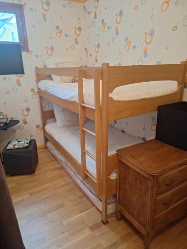 une chambre avec deux lits superposés et un bureau dans l'établissement Appartement St Lary Soulan village - Classé 3 étoiles et labelisé - WIFI inclus, à Saint-Lary-Soulan