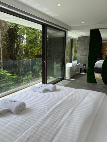a bedroom with a white bed with two towels on it at La Fortuna Villa - Award Winning Luxury Villa Close to Corfu Town in Corfu Town