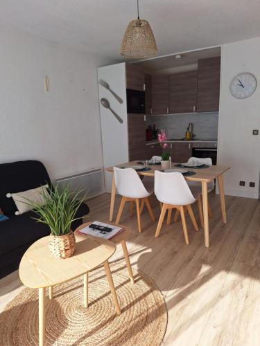 une cuisine et un salon avec une table et des chaises dans l'établissement Appartement St Lary Soulan village - Classé 3 étoiles et labelisé - WIFI inclus, à Saint-Lary-Soulan