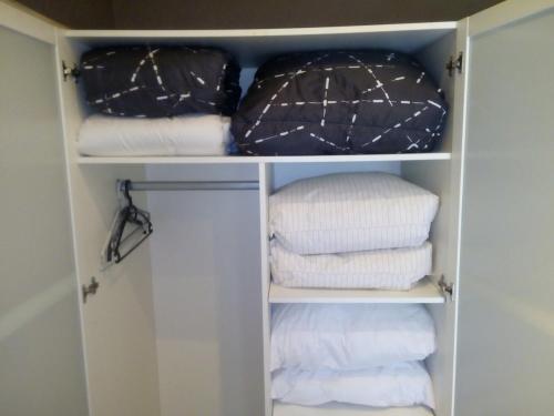 un placard rempli de serviettes blanches et de marbre noir dans l'établissement Appart au Lac d'Aiguebelette et Montagne, à Aiguebelette-le-Lac