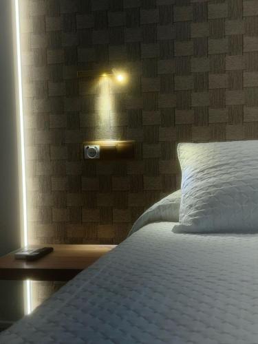 a bedroom with a bed with a light on the wall at Hotel Restaurant Llansola in Sant Carles de la Ràpita