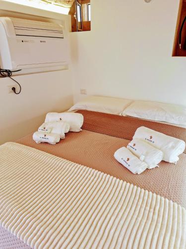two beds with towels on them in a room at Vico Farinella 12 Small Room in Polignano a Mare