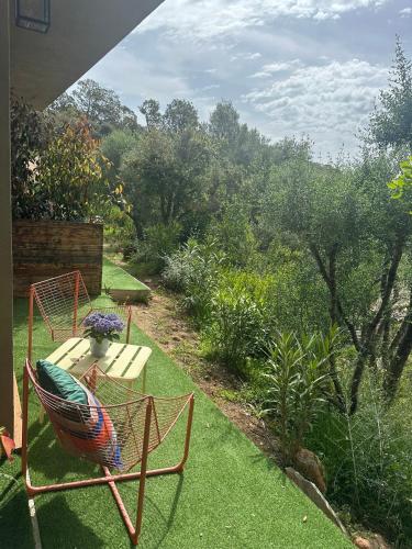 d'une terrasse avec 2 chaises et une table dans le jardin. dans l'établissement Casaty Mare, à Porto-Vecchio