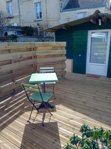 une table et une chaise sur une terrasse en bois dans l'établissement L 'Azuleja, à Fleury-sur-Orne