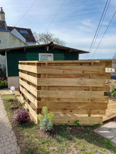 une clôture en bois devant une maison dans l'établissement L 'Azuleja, à Fleury-sur-Orne