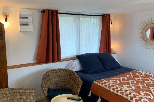 une petite chambre avec un lit et une fenêtre dans l'établissement L 'Azuleja, à Fleury-sur-Orne