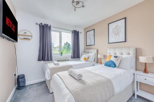 a bedroom with two beds and a window at Beautiful Apartment in City Centre with Free Parking, Balcony, Work Desk, Self-Check-In, Fast Wifi and Smart TVs by Yoko Property in Coventry