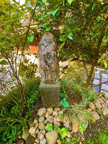 a stone statue in the middle of a garden at Puunee Wild River Villa's Borobudur in Borobudur