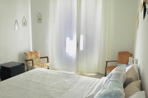 a bedroom with a white bed and a window at Avia Room in Pachino