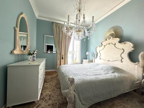 - une chambre avec un lit blanc et un lustre dans l'établissement Luxury apartment near MonteCarlo, à Beausoleil