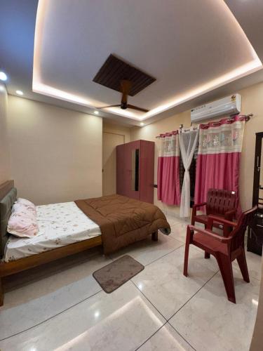 a bedroom with a bed and a chair at G3 nest in Mysore