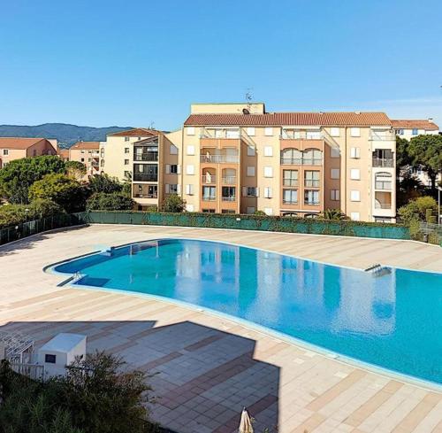 une grande piscine devant un immeuble dans l'établissement lagon bleu bali, à Fréjus