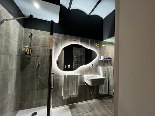 ein Badezimmer mit Dusche, Waschbecken und Spiegel in der Unterkunft Appartement Ombragé 44m2 Riviera Palace Belle-Epoque, Restomod et Literie Prestige in Menton