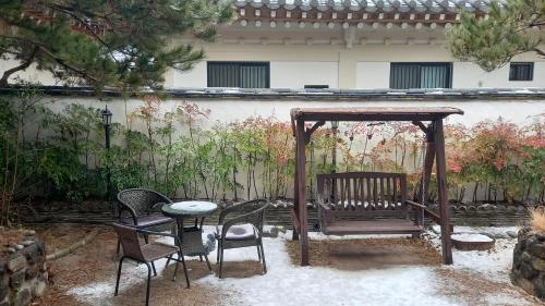 a gazebo with a table and chairs in a yard at Adam Guesthouse in Gyeongju