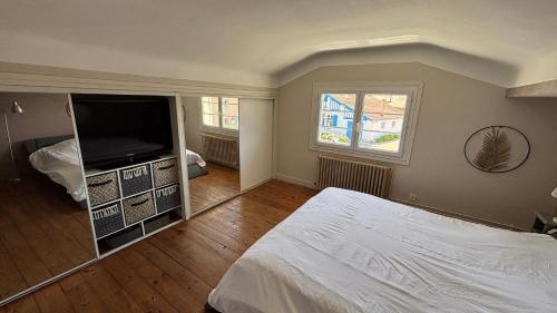 une chambre avec un lit et une télévision à écran plat dans l'établissement Villa TIKI BAR piscine chauffée 4 chambres, à Labenne