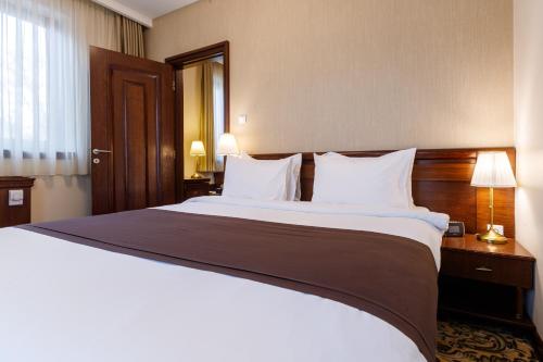 a hotel room with a large bed with white pillows at Hotel & Spa PALIĆ RESORT in Palić