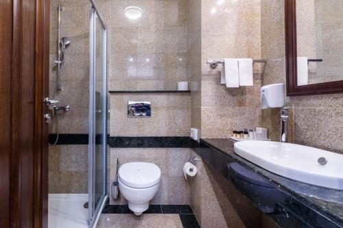 a bathroom with a toilet and a sink at Hotel & Spa PALIĆ RESORT in Palić