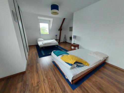 une chambre avec un grand lit et un parquet dans l'établissement Maison spacieuse à Saint-Lunaire, à Saint-Lunaire