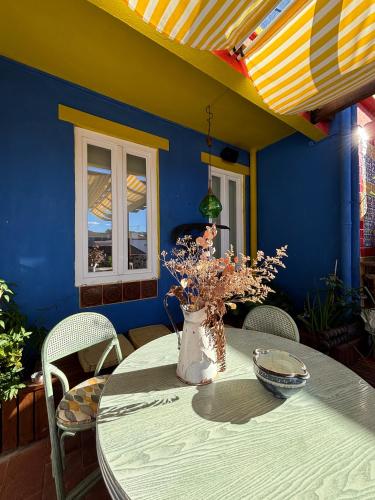 a dining room table with a vase of flowers on it at Soul - Coliving in Vila Franca de Xira