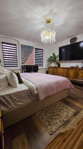 a bedroom with a large bed and a chandelier at Cozy Pet-Friendly Apartment in Meißen